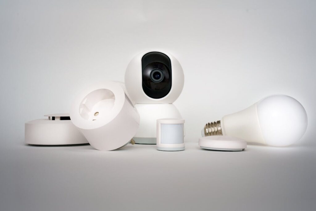 A range of smart home devices including camera and lightbulb in a minimalist setup.